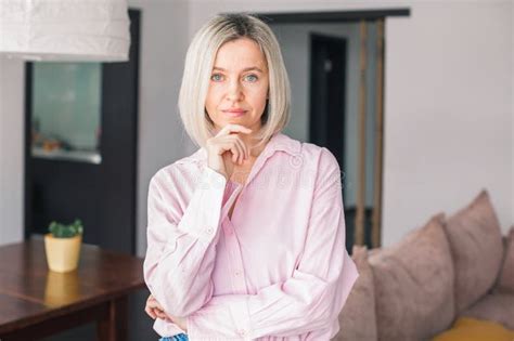 Smiling Middle Aged Mature Woman Looking At Camera At Home Stock Photo