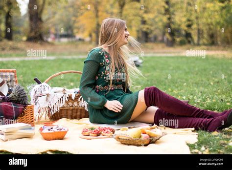 Beautiful Blonde Woman On A Picnic In The Park Waiting For Her Friends To Arrive Stock Photo