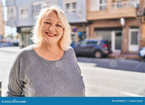 Middle Age Blonde Woman Smiling Confident Standing At Street Stock