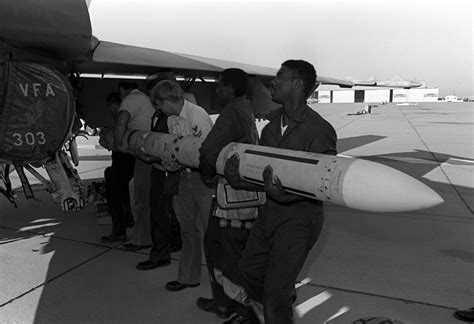 Aviation Ordnancemen Carry An Aim 7 Sparrow Missile To Its Attachment