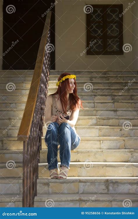 Uma Menina Senta Se Nas Escadas E Olha Se Para Fora A Janela Foto De