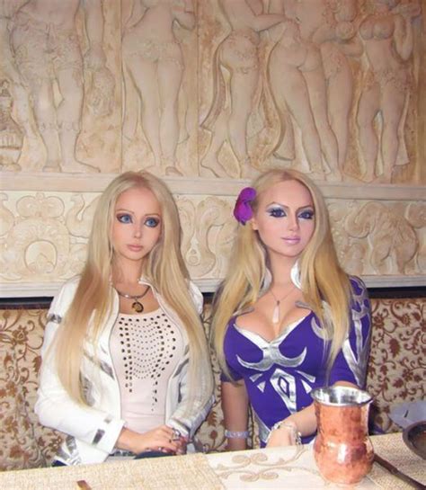 Two Barbie Dolls Standing Next To Each Other