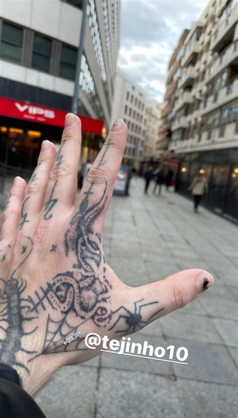 A Person S Hand With Tattoos On It Is In The Middle Of A Street