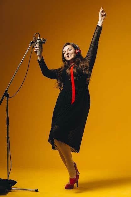 A cantora morena divertida positiva se divertindo canta a música jovem