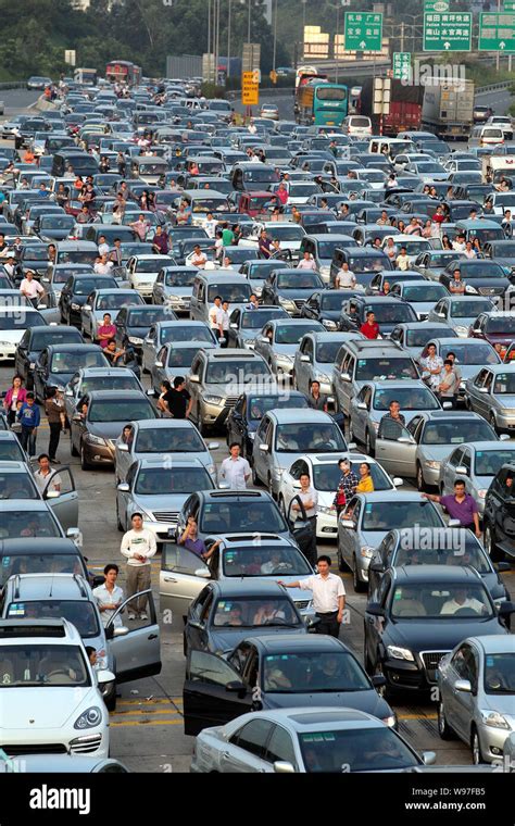 Chinese Holidaymakers Rest Next To Their Cars As They Are Waiting In A Long Queue In A Traffic