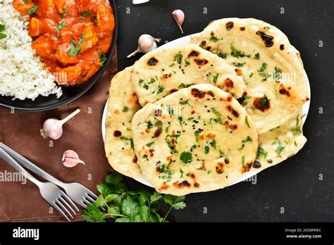 Indian Naan Bread And Chicken Curry Over Dark Stone Background Top