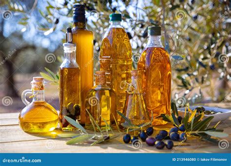 Bouteilles D Huile D Olive Et Branche D Olive Sur Une Table En Bois