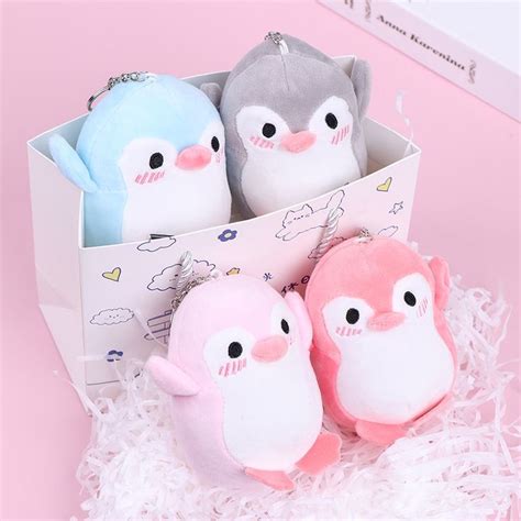 three small stuffed animals in a box on a pink surface with white ...