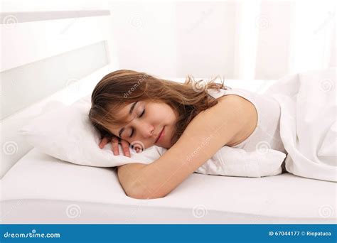 Jeune Femme Dormant Dans Le Lit Avec L Oreiller D Unter De Bras Image