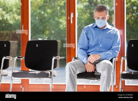 Sad Or Tired Mature Man With Face Mask Sitting In A Waiting Room Of A