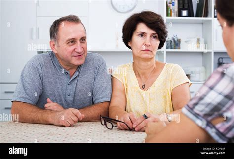 Serious Mature Couple Having Conversation With Adult Daughter At Home Stock Photo Alamy