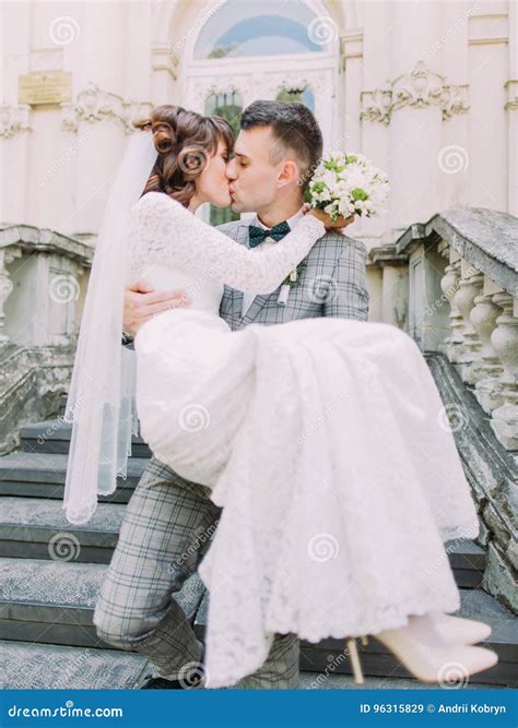 The Close Up Portrait Of The Groom Kissing The Bride While Carrying