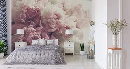 A Bed Room With A Neatly Made Bed And A Flower Wall Mural On The Wall