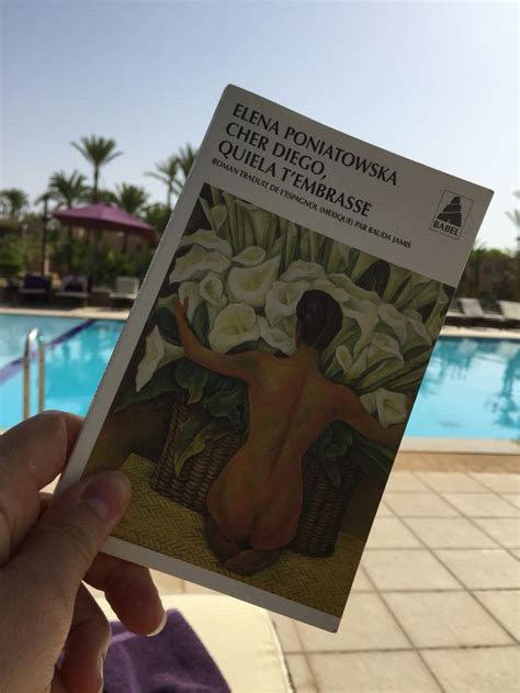 A Person Holding Up A Book In Front Of A Swimming Pool