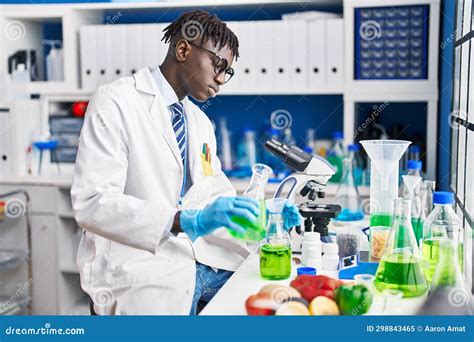 African American Man Scientist Pouring Liquid On Test Tube At