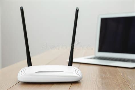 Modern Wi Fi Router And Laptop On Wooden Table Indoors Stock Photo