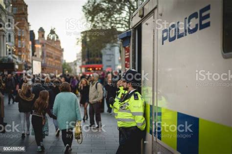 Policemen Patrolling The Crowded Streets Around Leicester Square In