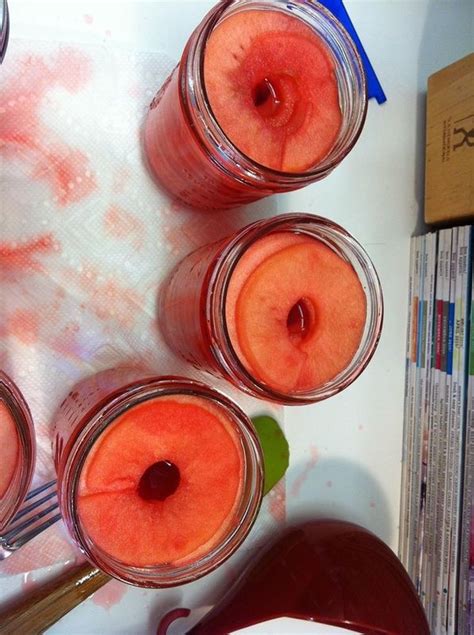 Four Jars Filled With Liquid Sitting On Top Of A Table