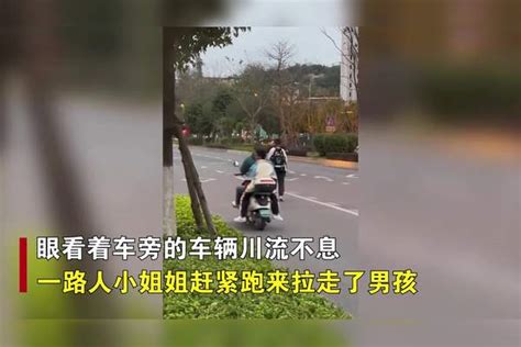 男孩精神恍惚，走向马路中央毫不知情被路人一把拉回，画面太后怕