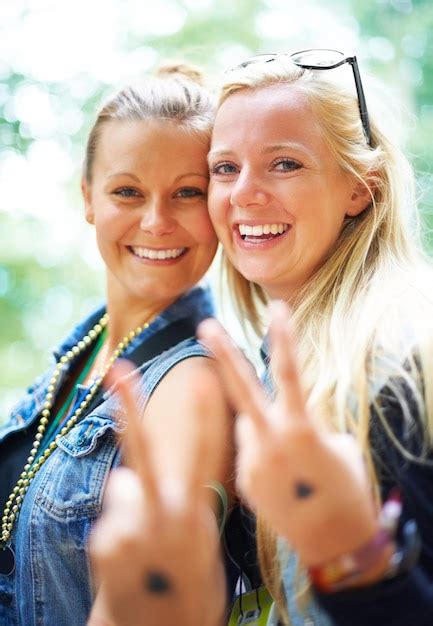 Premium Photo Portrait Of Smiling Sisters Gesturing Outdoors