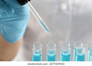 Scientist Dripping Liquid Pipette Into Test Stock Photo