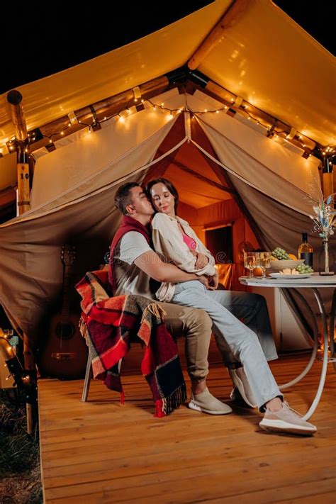 Happy Lovely Couple Relaxing In Glamping On Summer Evening And Drinking