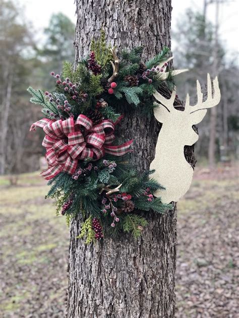 A Deer Head Hanging On The Side Of A Tree Next To A Christmas Wreath