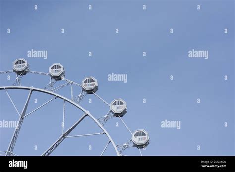 Cabins Of A Ferris Wheel Against The Blue Sky In The City Of Barcelona