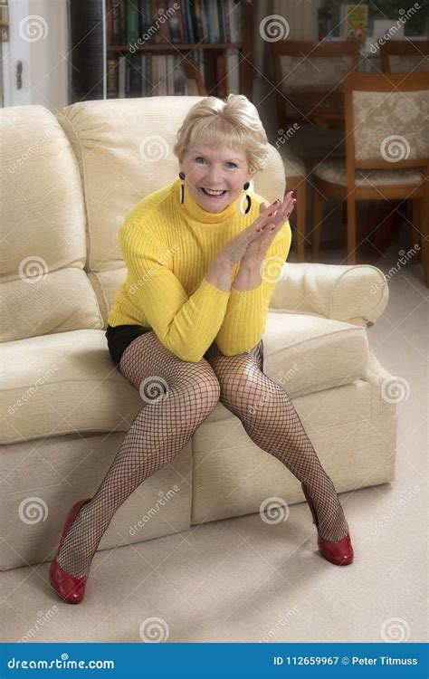 Woman Sitting On A Sofa Wearing Fishnet Tights Stock Image Image Of