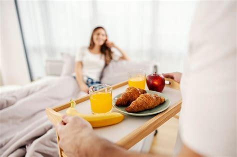 Premium Photo A Man Bringing A Healthy Breakfast In Bed For Him And