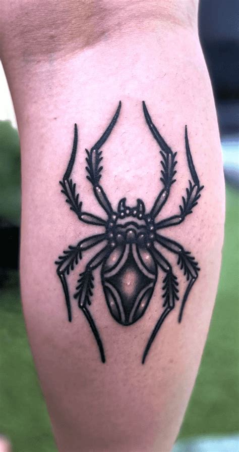 A Spider Tattoo On The Leg Of A Person With Black Ink And An Intricate