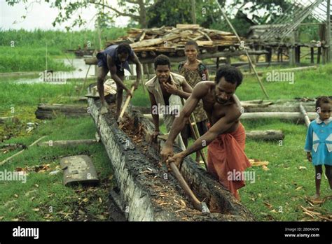 Papua New Guinea Sepik River Men Carving Dugout Canoe From Tree Trunk