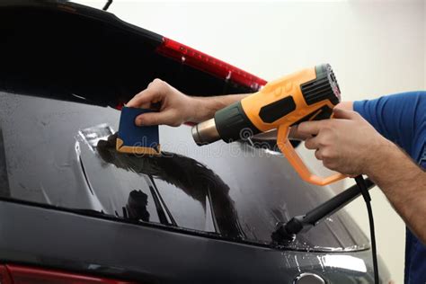 Worker Tinting Car Window With Heat Gun In Workshop Stock Photo Image