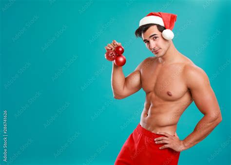 Foto De Sexy Shirtless Santa Claus With Christmas Balls On Blue Background Space For Text Do