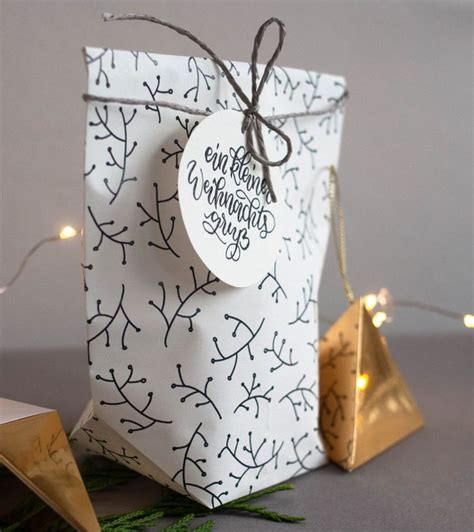 A Gift Bag With A Tag On It Sitting Next To Some Christmas Decorations