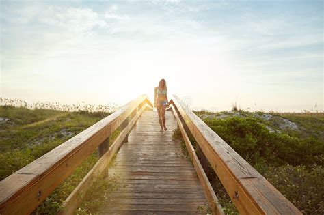 The Bridge To The Beach A Young Woman In A Bikini On A Walkway Near