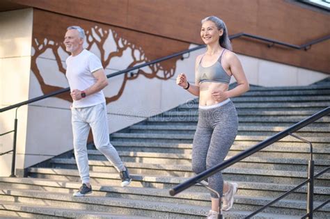 A Mature Couple Having A Morning Jogging Together And Looking Contented