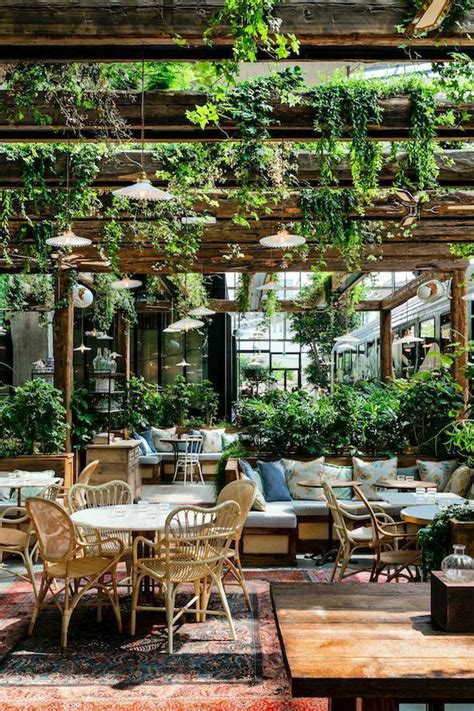 An Outdoor Dining Area With Tables Chairs And Potted Plants Hanging