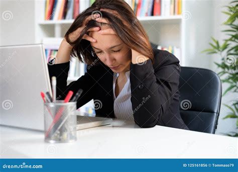 Tired And Stressed Employee At Work Sitting In The Office Stock Photo