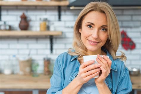 Retrato de um sorrindo mulher jovem segurando branca xícara café