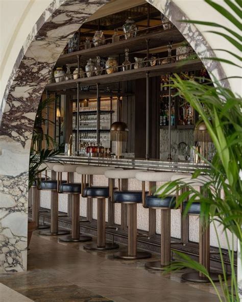 A Bar With Several Stools In Front Of It And An Archway Leading Into