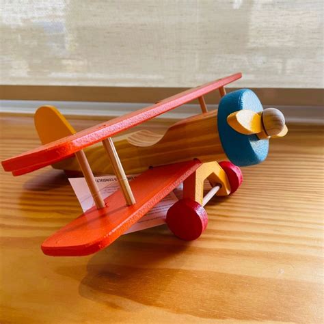 Avião Biplano Laranja de Madeira Brinquedo Educativo Ioiô de Pano