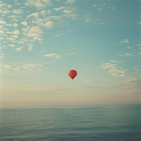 A Hot Air Balloon Flying Over The Ocean Premium AI Generated Image