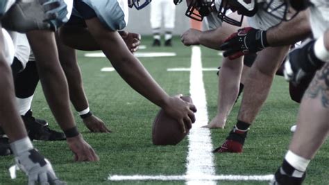 Close Up Of Football Players Linemen Lining Up And Snapping The Ball