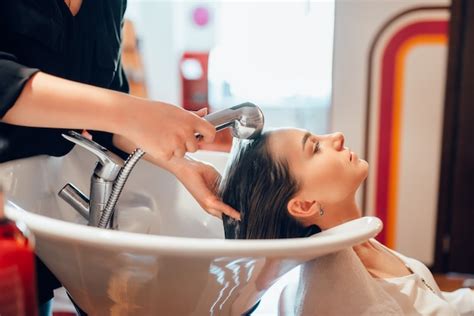 Premium Photo Hairdresser Washes Customer Hair In Basin