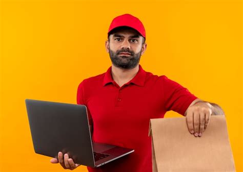 Free Photo Bearded Delivery Man In Red Uniform And Cap Holding Paper