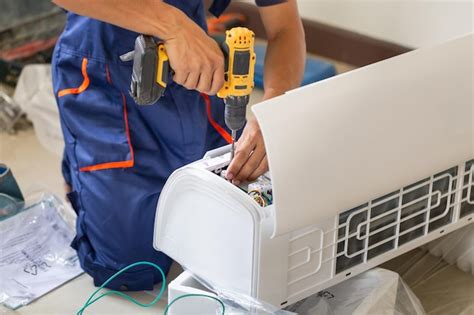 Hombre técnico asiático instalando un aire acondicionado en la casa de