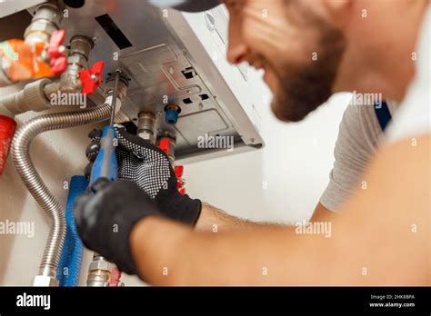 Closeup Of Plumber Using Screwdriver While Installing New Steel Hot