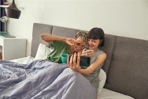 Lesbianas Sonrientes Descansan Y Tocan En La Cama En Casa Imagen De