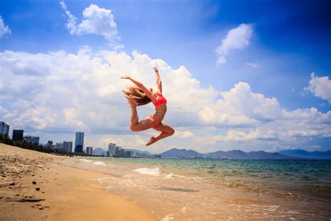 Blondes Dünnes Mädchen Im Bikini Macht Spalte Auf Nassem Sandlächeln in Meer Stockbild Bild